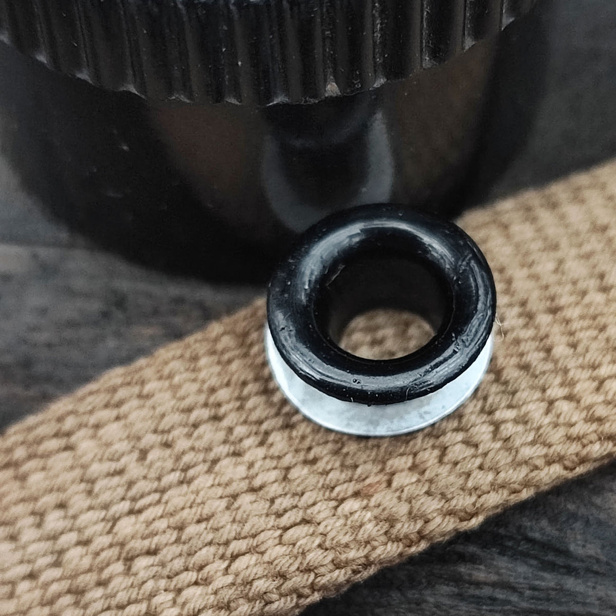 Aluminum grommet for field bottle cap